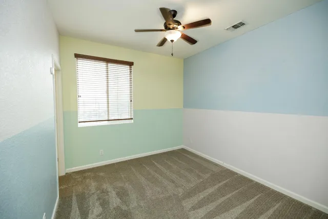 a view of a room with a ceiling fan and a window