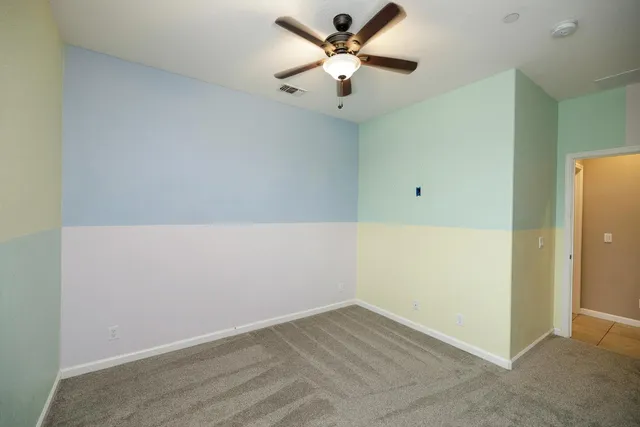 an empty room with a ceiling fan and a window