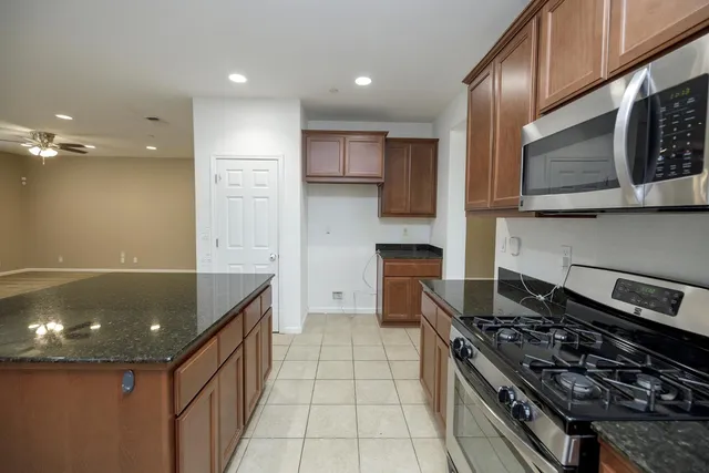 a large kitchen with stainless steel appliances granite countertop a stove and a sink
