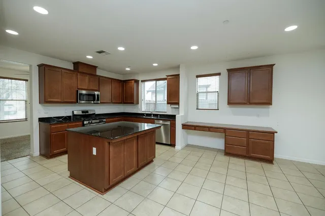 a kitchen with stainless steel appliances granite countertop a stove a sink and a microwave