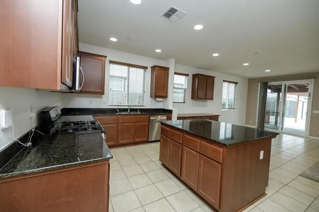 a large kitchen with stainless steel appliances lots of counter space and windows