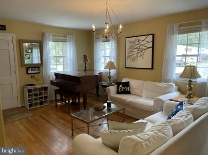 a living room with furniture a dining table and a piano