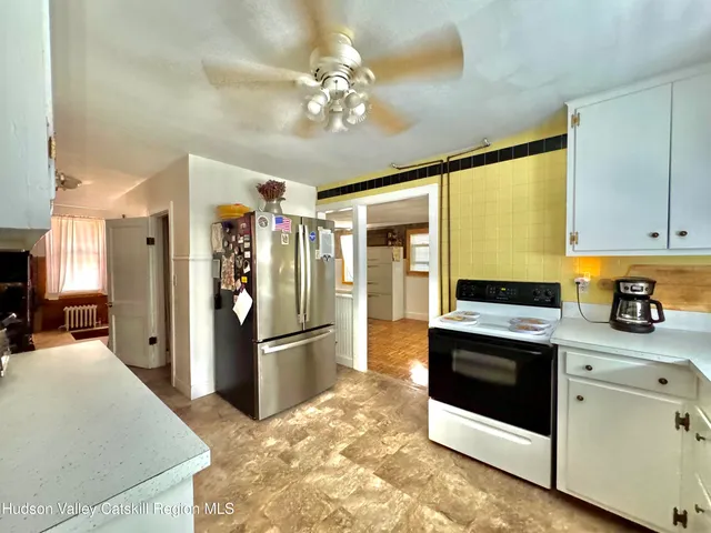 a kitchen with stainless steel appliances kitchen island granite countertop a refrigerator and a stove top oven