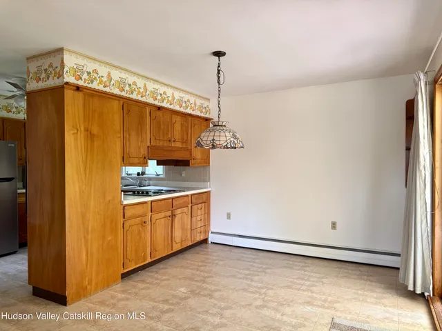 a kitchen with stainless steel appliances granite countertop a refrigerator a sink dishwasher a stove and white cabinets with wooden floor