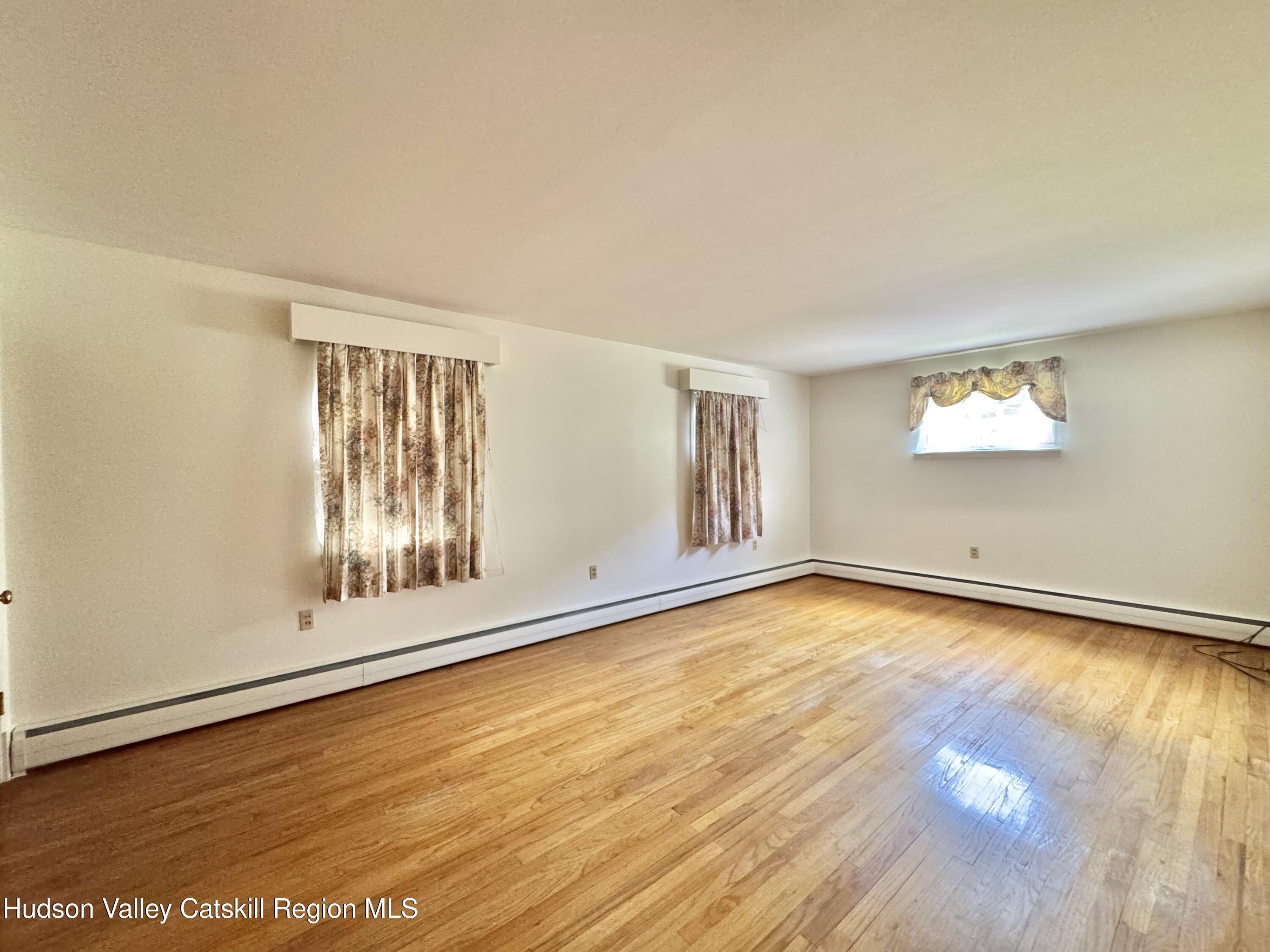 189-195 Vedder Road Catskill, NY 12414 - Photo 31 of 39 a view of an empty room with wooden floor and a window