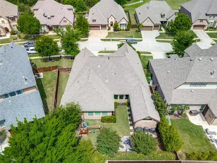 an aerial view of a house with garden space and a patio