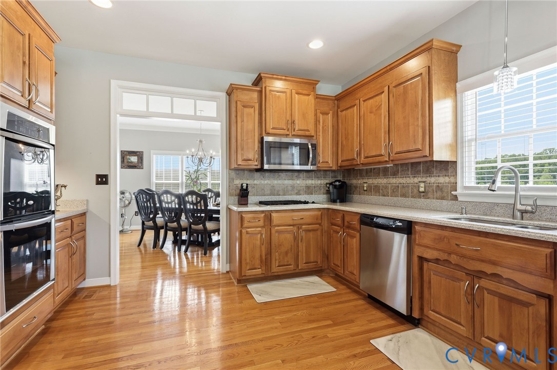 2018 Old Church Road Mechanicsville, VA 23111 - Photo 14 of 49 a kitchen with stainless steel appliances granite countertop a stove top oven a sink a dining table and chairs