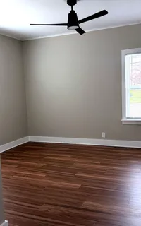 a view of a room with wooden floor and fan