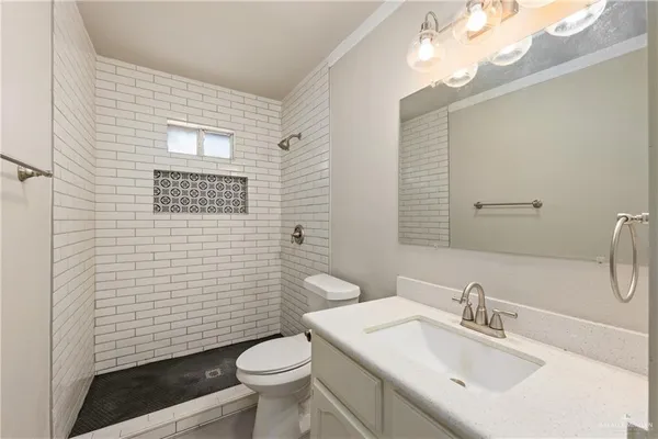 a bathroom with a sink a toilet and shower