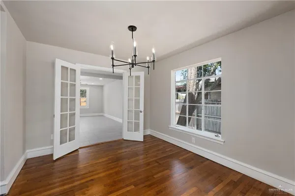 a view of empty room with wooden floor and window