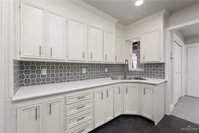 a kitchen with granite countertop white cabinets and sink