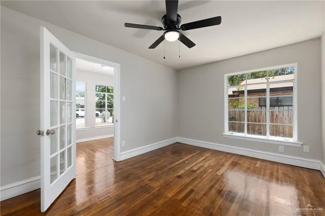 an empty room with wooden floor and windows
