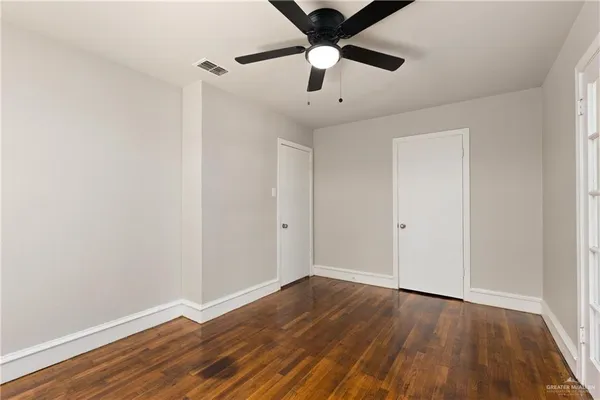 a view of an empty room with wooden floor