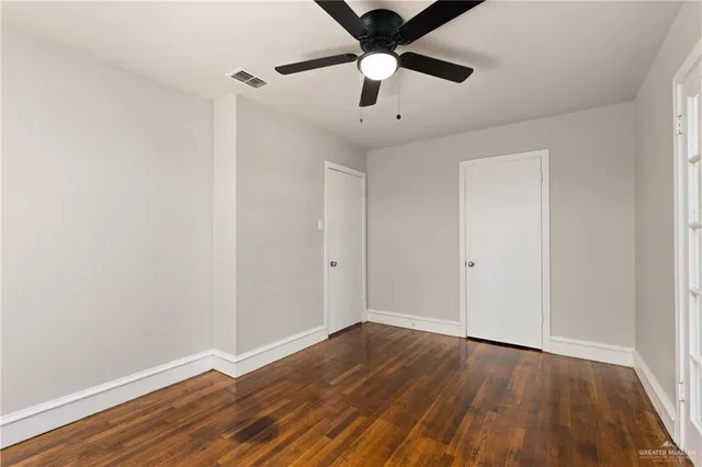 a view of an empty room with wooden floor