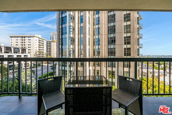 a balcony with outdoor seating and city view