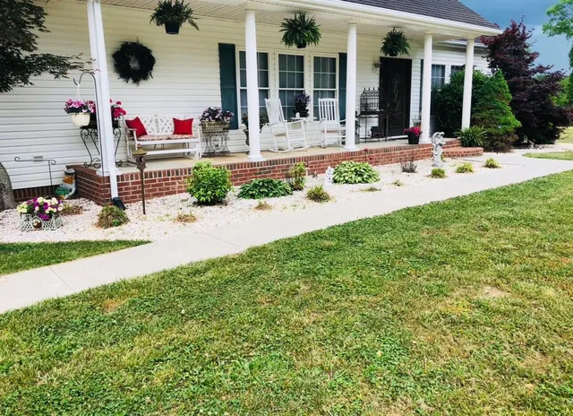 front view of house with a yard and potted plants