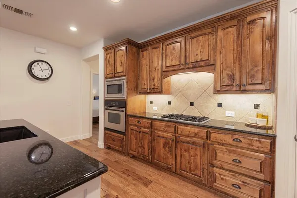 a kitchen with granite countertop stainless steel appliances and wooden cabinets