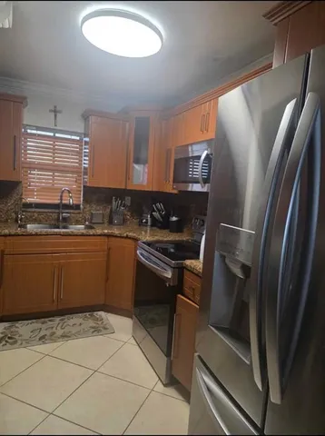 a kitchen with stainless steel appliances granite countertop a refrigerator sink and stove