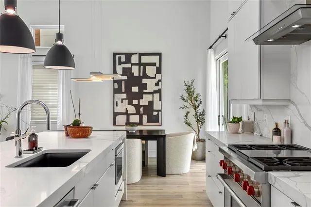 a kitchen with stainless steel appliances a sink a stove and a wooden floors
