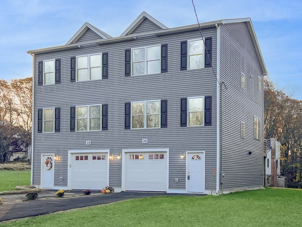 a view of a brick house with a yard and large tree