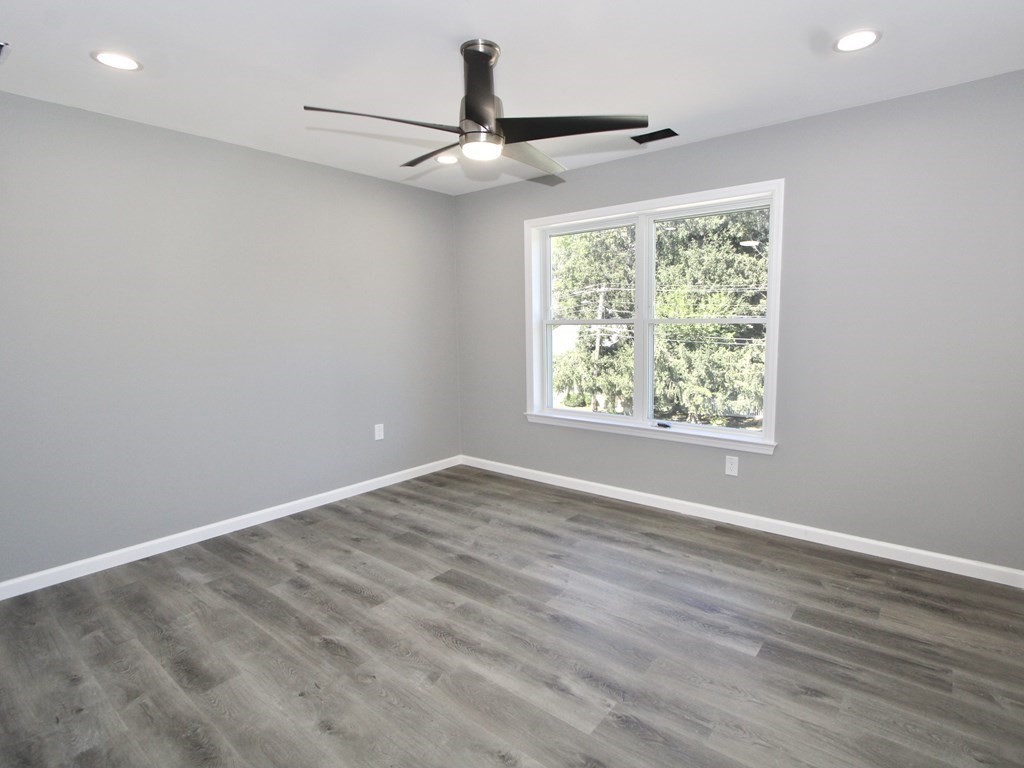 26 Apthorp Street Worcester, MA 01606 - Photo 7 of 13 an empty room with wooden floor fan and windows