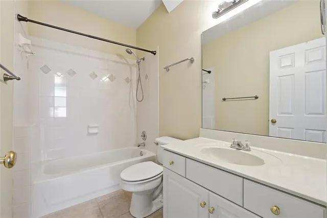 a bathroom with a granite countertop sink a toilet and shower
