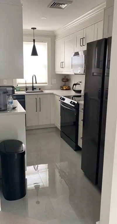 65 Louis Street, Unit A Barnstable, MA 02601 - Photo 14 of 28 a kitchen with stainless steel appliances a refrigerator a sink a stove and white cabinets