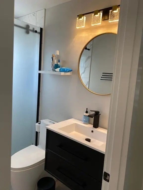 65 Louis Street, Unit A Barnstable, MA 02601 - Photo 22 of 28 a bathroom with a sink a toilet and a mirror