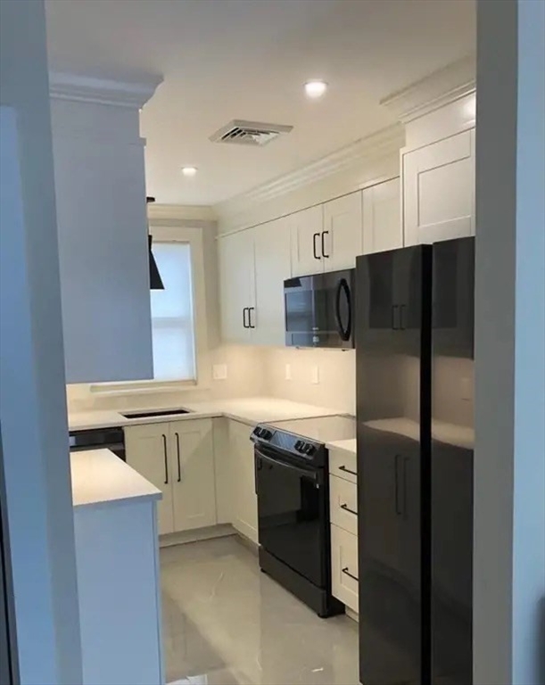65 Louis Street, Unit A Barnstable, MA 02601 - Photo 23 of 28 a kitchen with stainless steel appliances a refrigerator sink and microwave