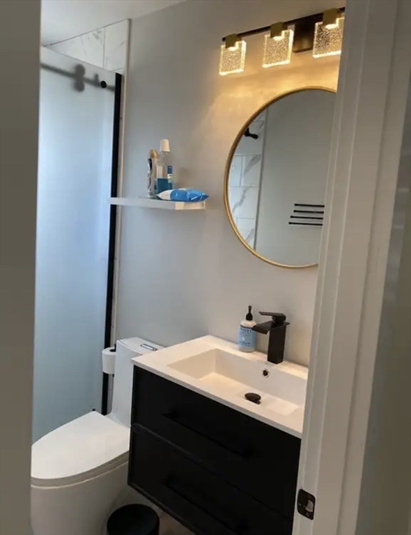 65 Louis Street, Unit A Barnstable, MA 02601 - Photo 9 of 28 a bathroom with a sink a toilet and a mirror