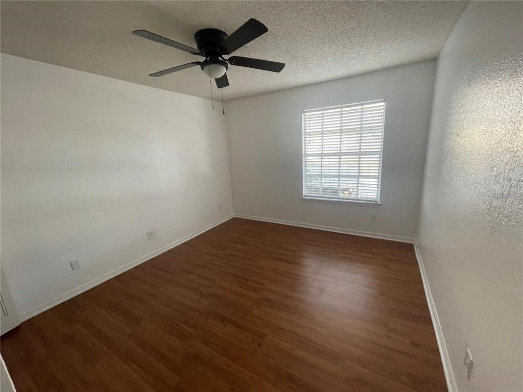 1027 South Hiawassee Road, Unit 2323 Orlando, FL 32835 - Photo 11 of 20 an empty room with wooden floor and windows