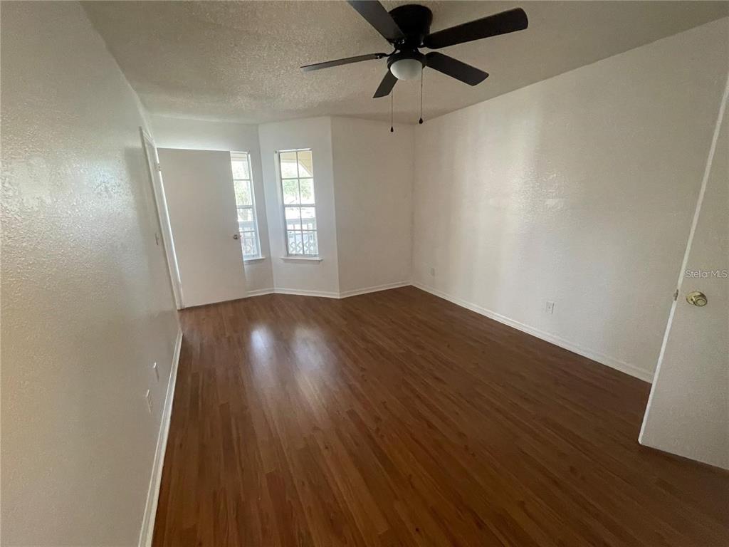 1027 South Hiawassee Road, Unit 2323 Orlando, FL 32835 - Photo 12 of 20 an empty room with wooden floor fan and windows