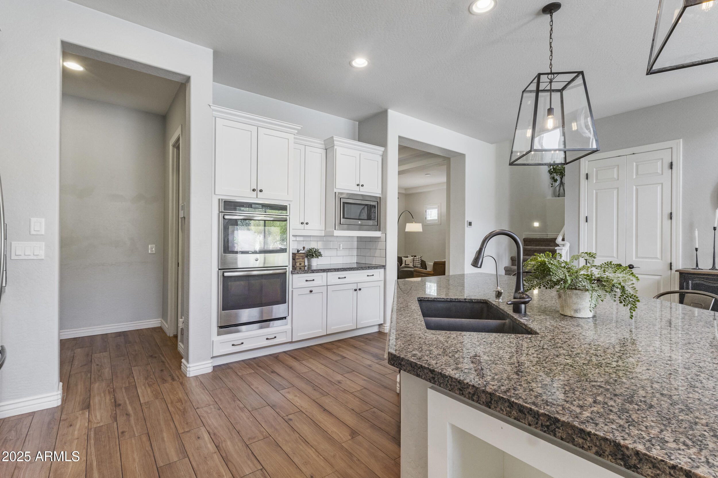 4292 East Morrison Ranch Parkway Gilbert, AZ 85296 - Photo 12 of 55 a kitchen with stainless steel appliances granite countertop a sink cabinets and wooden floor