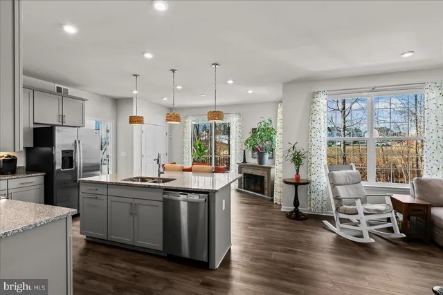 a kitchen with stainless steel appliances granite countertop a sink and wooden floors