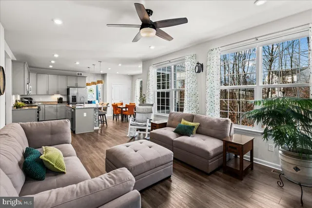 a living room with furniture and a large window with wooden floor