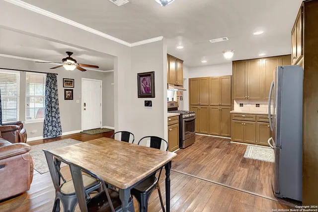 a kitchen with stainless steel appliances refrigerator dining table and chairs