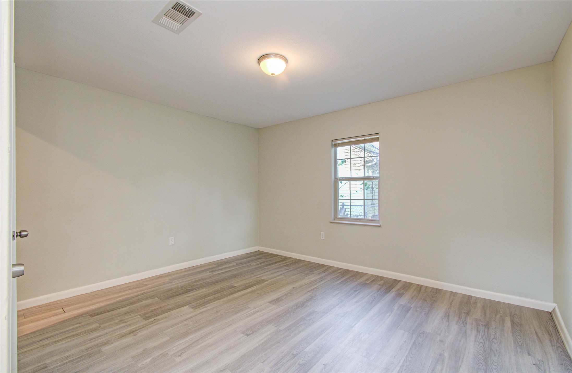 4624 Kingsbury Street Houston, TX 77021 - Photo 16 of 31 an empty room with wooden floor and windows