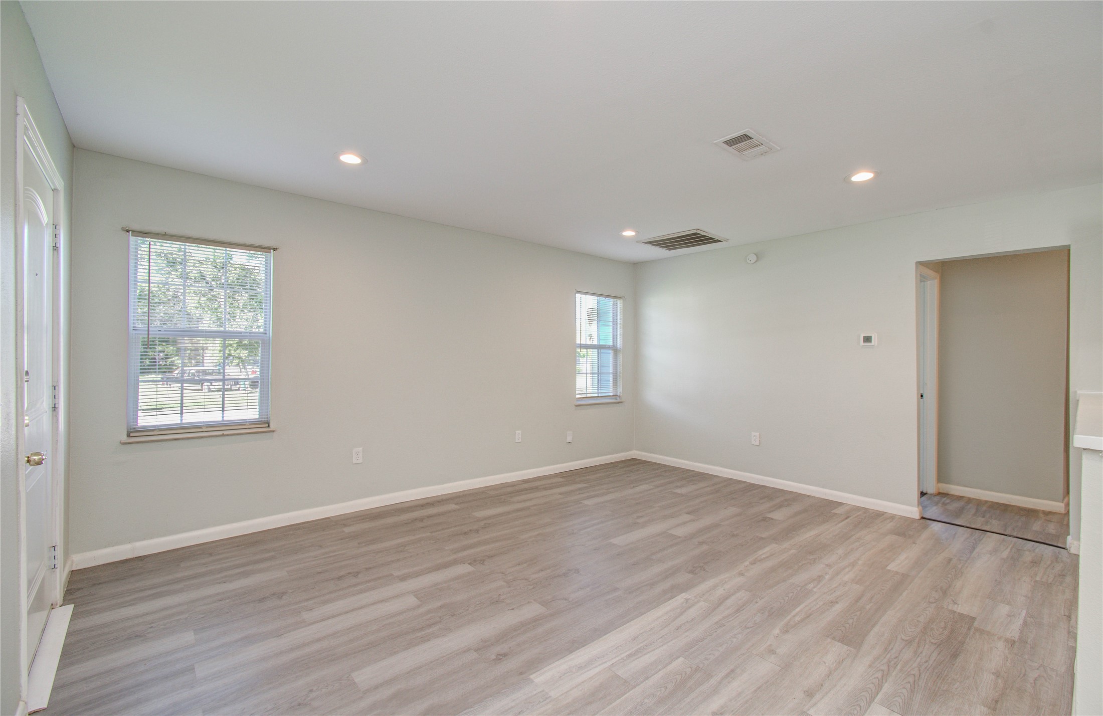 4624 Kingsbury Street Houston, TX 77021 - Photo 7 of 31 an empty room with wooden floor and windows