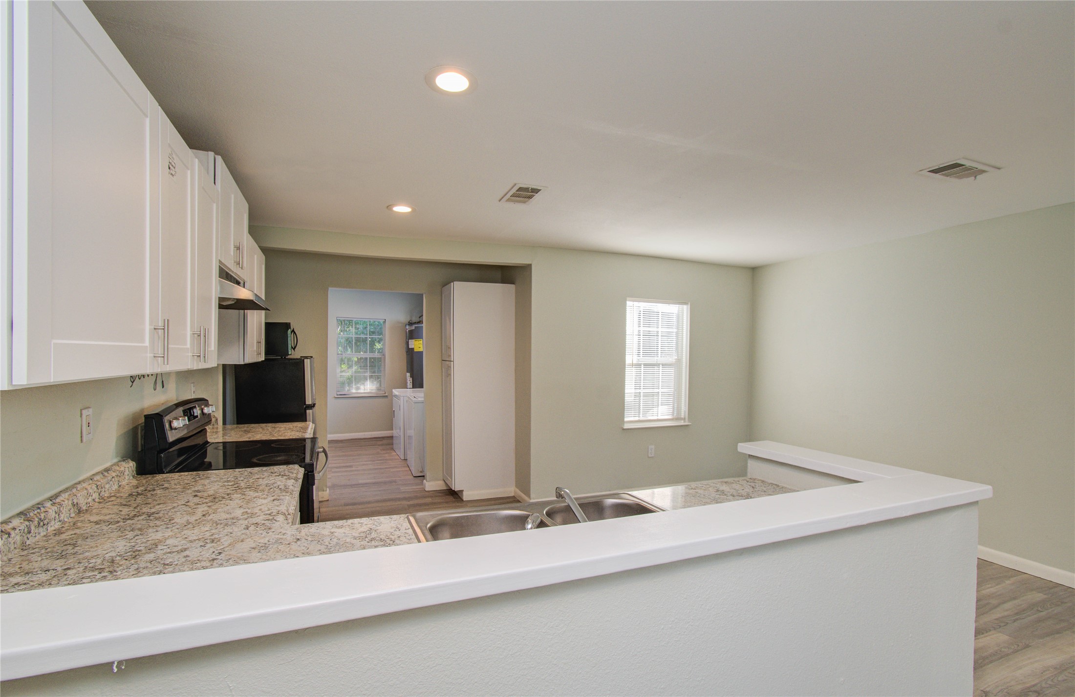 4624 Kingsbury Street Houston, TX 77021 - Photo 10 of 31 a view of kitchen island a sink wooden floor and a granite counter top