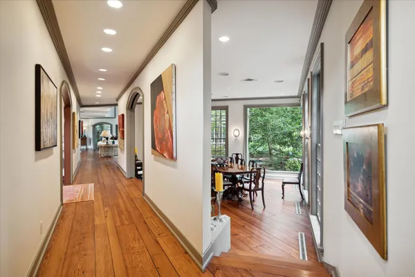 a view of a hallway with wooden floor and windows