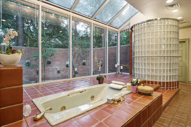 a bathroom with a tub sink and glass door