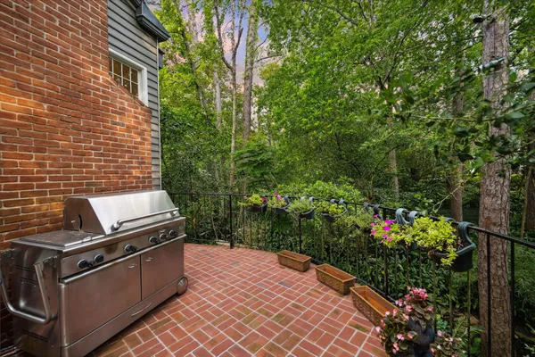 a view of a backyard with chairs and flower plants