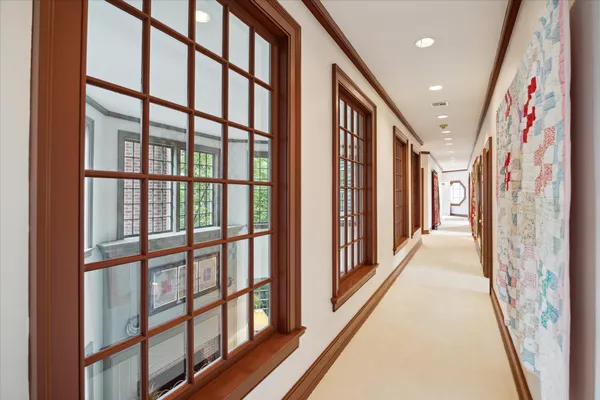 a view of a hallway with wooden floor and windows