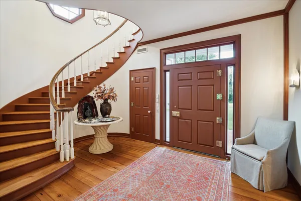 a view of entryway and hall with wooden floor