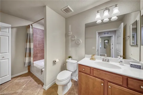 a bathroom with a sink a toilet a large mirror and shower
