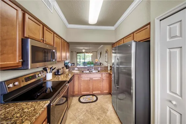 a kitchen with refrigerator a microwave a stove and white cabinets with wooden floor