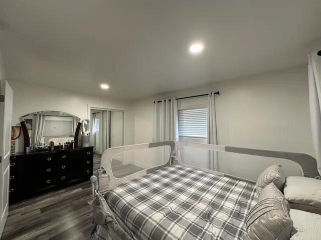 a bedroom with a bed window and dresser