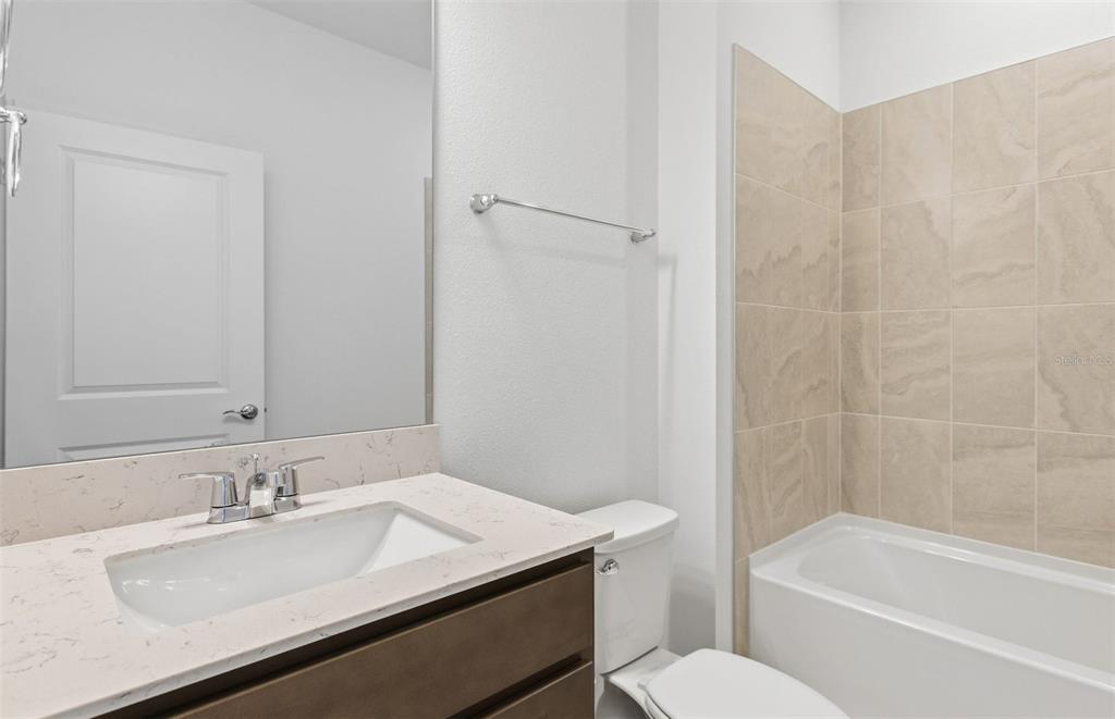 6933 Southwest 90th Place Ocala, FL 34476 - Photo 12 of 17 a bathroom with a granite countertop sink toilet and shower