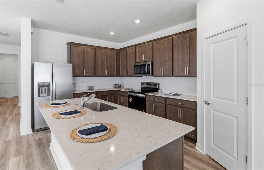 6933 Southwest 90th Place Ocala, FL 34476 - Photo 3 of 17 a kitchen with a sink a stove and refrigerator