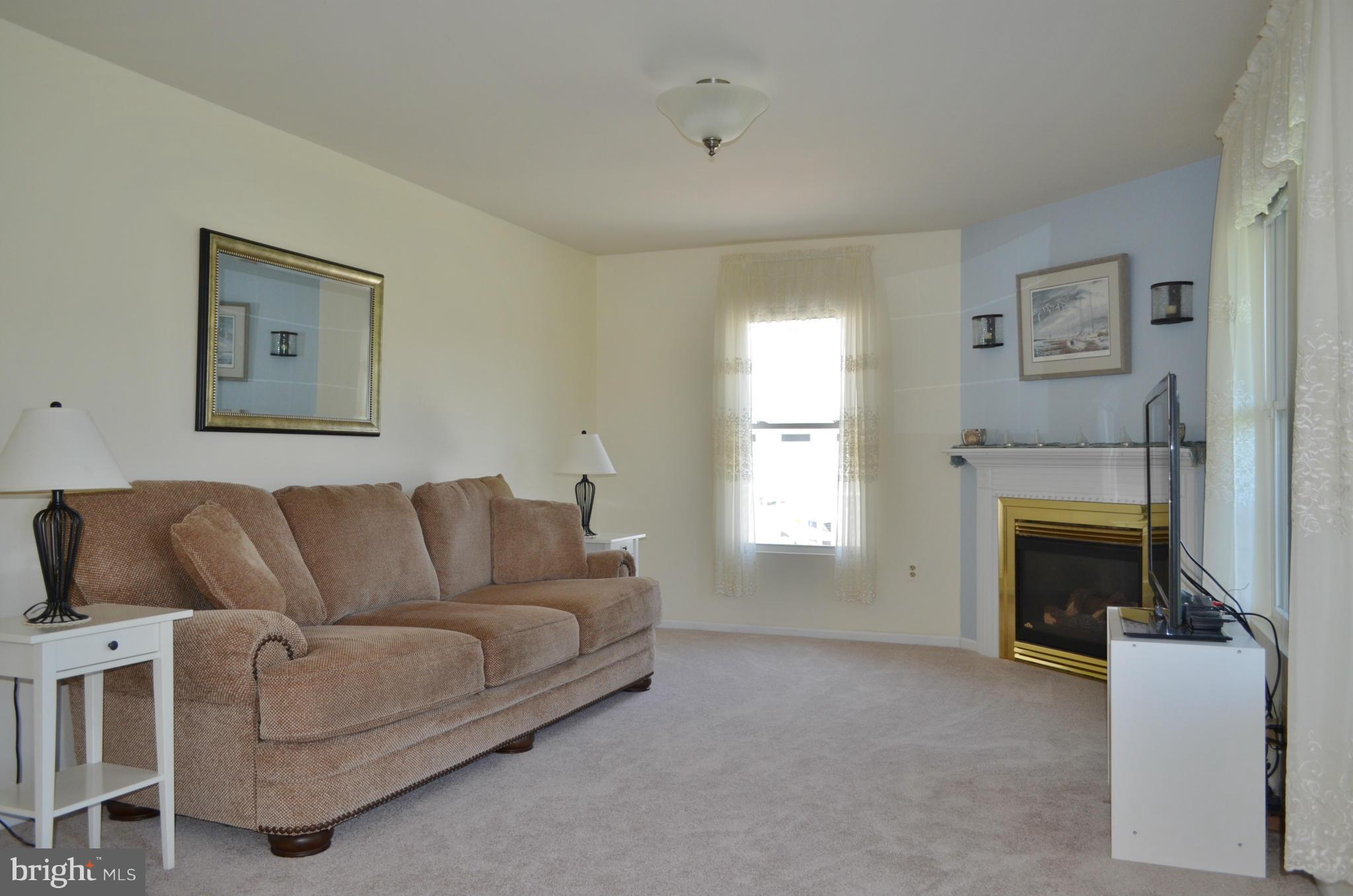 75 Fairhaven Road Tracys Landing, MD 20779 - Photo 6 of 30 a living room with furniture a flat screen tv and a fireplace